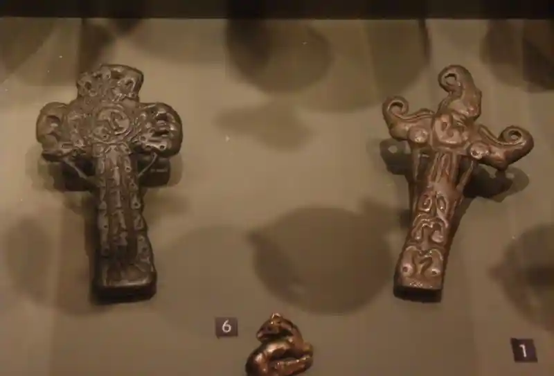 Bronze crucifix with symbols engraved on it.